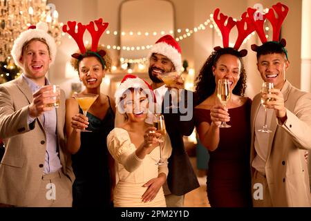 Portrait Of Friends Wearing Santa Hats And Reindeer Antlers At Christmas Or New Year Party Stock Photo