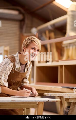 Female Apprentice Working As Carpenter In Furniture Workshop Stock Photo