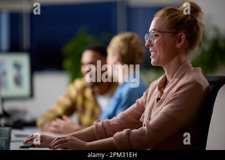 Business Team Using Computers At Desks In Office Working Late Stock Photo