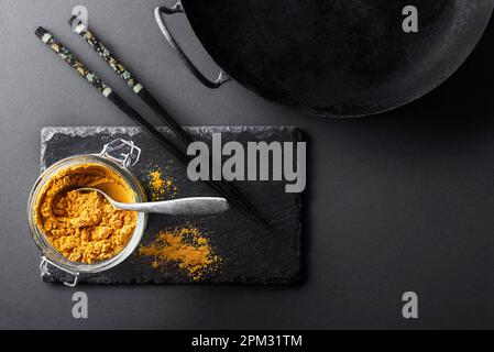 Turmeric powder(curcuma) is one of the key ingredients in many Asian dishes and wok- frying pan used typically in Chinese cooking Stock Photo