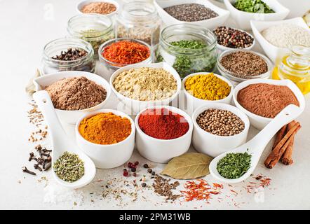 Colorful herbs and spices for every cooking style and in every kitchen. Indian and asian and japanese spices on white stone background close up Stock Photo