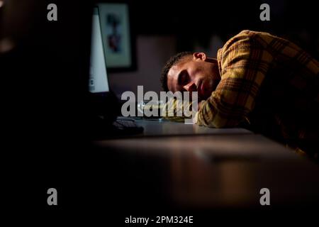 Businessman Working Late In Office Sleeping At Desk Stock Photo