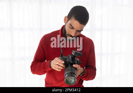 Handsome young man professional photographer using digital camera Stock Photo