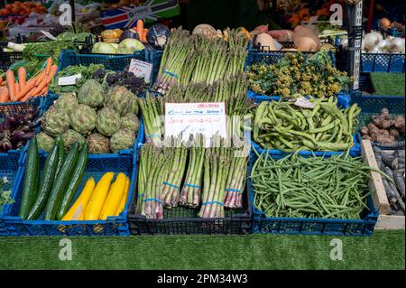 Fresh asparagus and other vegetables for sale and on display on a market stall in spring Cambridge UK Stock Photo
