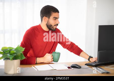 Handsome hispanic young man working at office Stock Photo