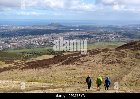 Edinburgh, Scotland, UK. 11th April 2023. Walkers enjoying the good weather this morning on the various paths and trails around the Pentland Hills Regional Park. View over Edinburgh South city rooftops towards Arthurs Seat. Credit: Craig Brown/Alamy Live News Stock Photo