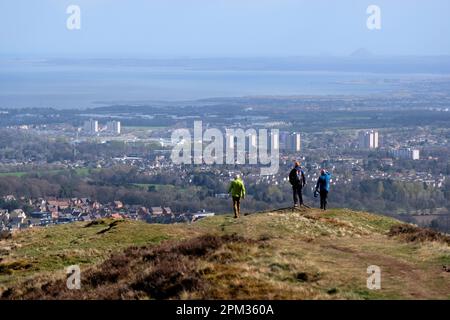 Edinburgh, Scotland, UK. 11th April 2023. Walkers enjoying the good weather this morning on the various paths and trails around the Pentland Hills Regional Park. View Eastwards over the Forth Estuary and  Berwick Law visible on the horizon at North Berwick.  Credit: Craig Brown/Alamy Live News Stock Photo