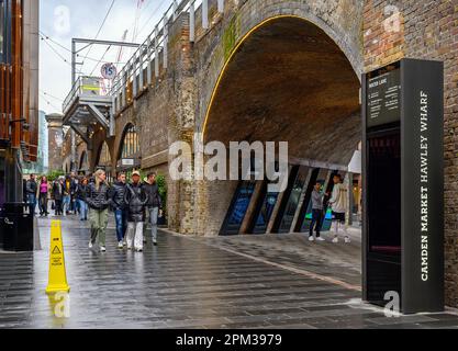 Camden Town, London, UK: Hawley Wharf, part of Camden Market. People walking in Water Lane by the railway viaduct. Stock Photo