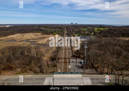 An aerial view of the train tracks in Pelham Bay by the dry marsh waters in Bronx, New York during a sunny morning Stock Photo