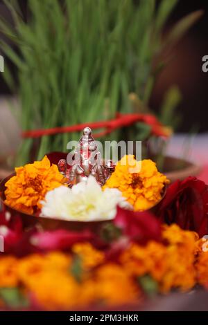 Ganesh statue and flower in the pot on the table, Indian Rituals, Ganesh Sthapana, Ganesh Puja,  Ganesh Chaturthi Festival Stock Photo