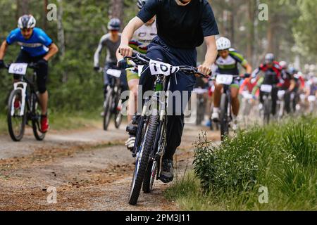 leader cyclist ahead group athlete mountainbikers riding cross-country cycling competition Stock Photo
