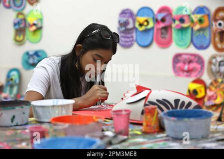 Dhaka, Bangladesh - April 11, 2023: Bangladeshi students of the Institute of Fine Arts in Dhaka University give finishing touch to the colorful masks Stock Photo