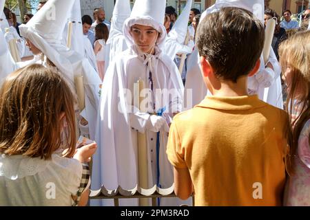 Seville Spain. Holy Week or Semana Santa. Children are given sweets during the procession to Seville's Cathedral on Palm Sunday, Domingo de Ramos. Stock Photo