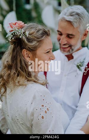 Close-up of bride and groom dancing at their outdoor wedding party. Stock Photo