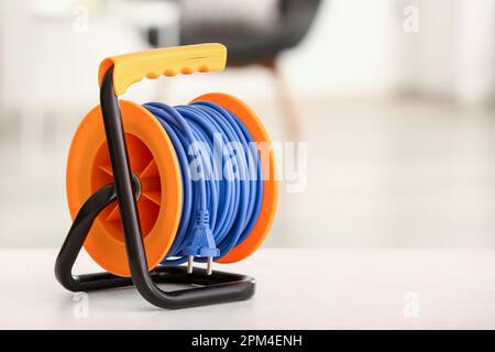 Extension electric cable reel on table Stock Photo