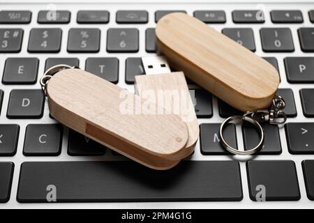 Wooden USB flash drives on modern laptop, closeup Stock Photo