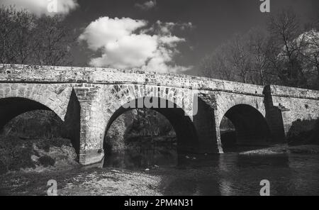 Roman bridge on old royal road from Paris to Sens over Yerres river near Evry-Gregy-sur-Yerre and medieval town of Brie-Comte-Robert. Black white Stock Photo