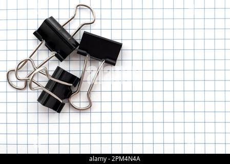 A sheet of paper in a cage for notes with a paper clip on a white background. Entries. Notes. Reminder Stock Photo