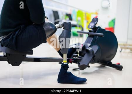 Disabled sporty man exercising with prosthetic leg at gym Stock Photo