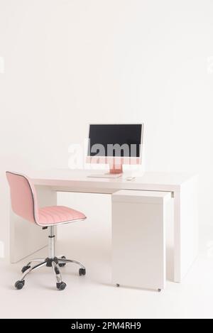 England, UK. 2023. An office, pink desk, pink chair and pink computer against a white background. Stock Photo