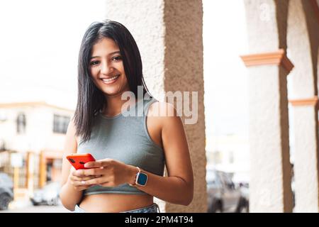 Young latin american woman using smartphone. Stock Photo