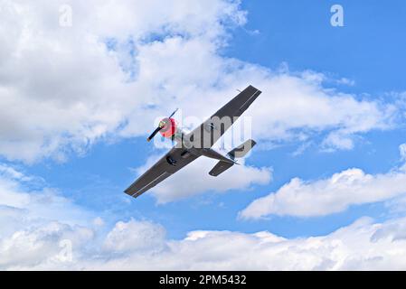 View of an aerobatic plane (aerodyne), in flight under a blue sky with white clouds. flight exhibitions Stock Photo