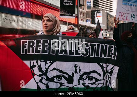 New York, United States. 08th Apr, 2023. Standing in front of the US Army recruiting station in Times Square, a protestor holds a banner that reads 'Free Palestine.' Hundreds of protestors gather in Times Square in response to Israeli police raiding Al-Aqsa mosque in Jerusalem, on April 8, 2023, in New York. (Photo by Olga Fedorova/SOPA Images/Sipa USA) Credit: Sipa USA/Alamy Live News Stock Photo