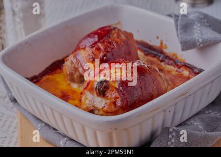 Chicken thighs filled with cheese and wrapped in bacon. Stock Photo