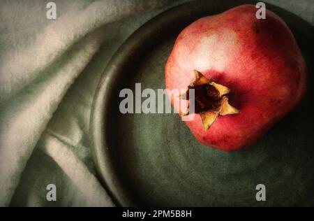 One pomegranate on round plate close up Stock Photo