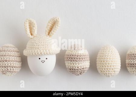 easter eggs in crochet hat with bunny ears on white background Stock Photo