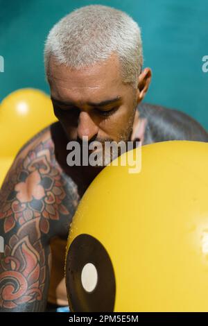 Young stylish tattooed spanish man in the pool. Stock Photo
