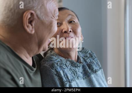 Happy senior couple at home next to the window Stock Photo