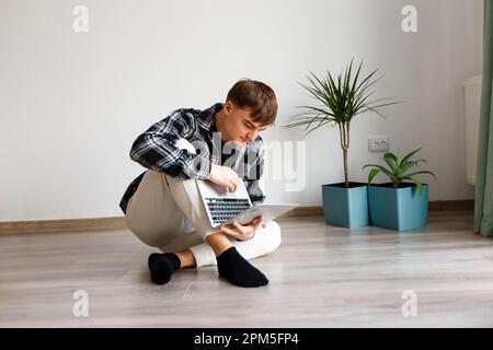 man spends time at the laptop at home studying and working Stock Photo