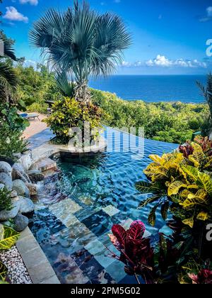 Beautiful swimming pool in tropical setting with view of ocean Stock Photo