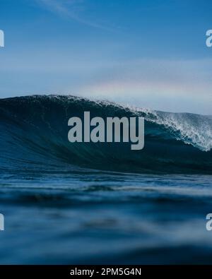 Close up of Breaking wave against blue sky Stock Photo