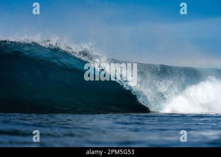 Close up of Breaking wave against blue sky Stock Photo
