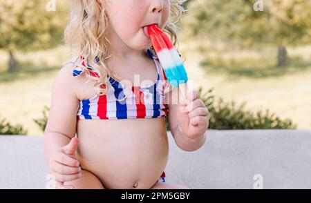 Girl in a blue bathing suit lies on the seashore and relaxes. Waves