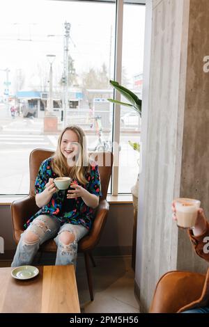 Happy friends chatting with coffee in cafe Stock Photo