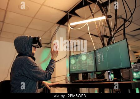 Hacker coding script in vr headset, cracking password in metaverse and hacking online server. Young woman stealing sensitive information with virtual reality glasses, cyberterrorism. Stock Photo