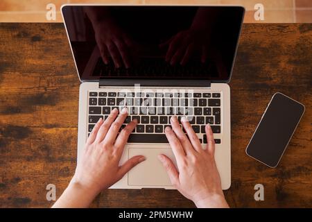 Close up of businesswoman using laptop at desk in creative office Stock Photo