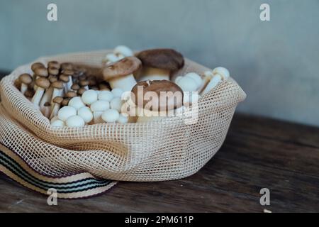 Various edible Asian mushrooms. Set of vegetables in eco bag. Natural light. Stock Photo