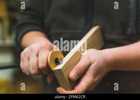Closeup shot of adult caucasian male carpenter using marking gauge on wooden plank. Professional woodworking tool. High quality photo Stock Photo