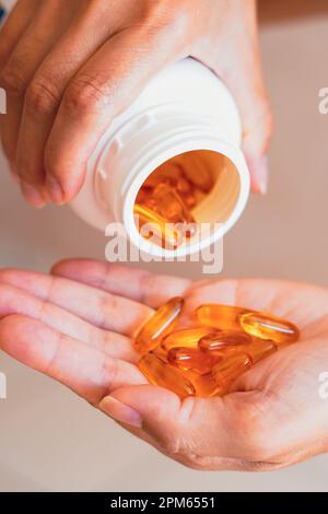 In this photo illustration, a person holds several medicine pills in his hand Stock Photo