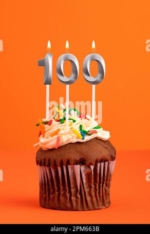 Candle number 100 - Cake birthday in orange background Stock Photo