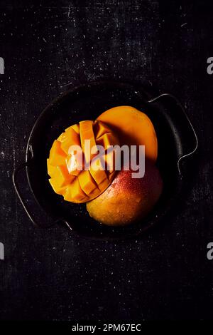 Fresh Mango on black tray and black background Stock Photo