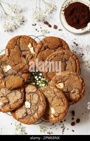 Chocolate chip coffee cookies presented on a wire tray with a bowl of ground espresso coffee alongside. Stock Photo