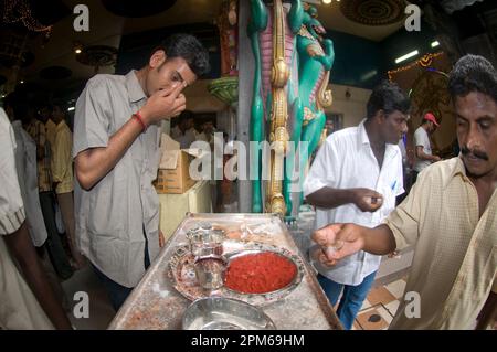 Male devotees applying white bindi at Deepavali ceremony, Sri Veeramakaliamman Temple, Little India, Singapore Stock Photo