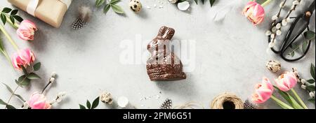 Easter background with spring flowers, eggs, feathers, gift boxes on light grey background top view flat lay copy space mock up Stock Photo