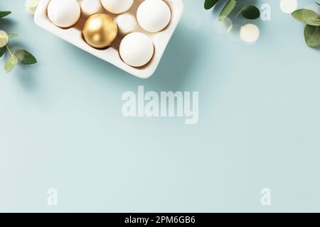 Easter table decorations. Happy Easter concept with golden table setting, easter eggs, feathers and spring flowers. Easter background with copy space. Stock Photo