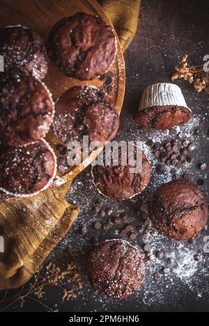 Homemade chocolate muffins with cholcolate chips in a rustic kitchen Stock Photo